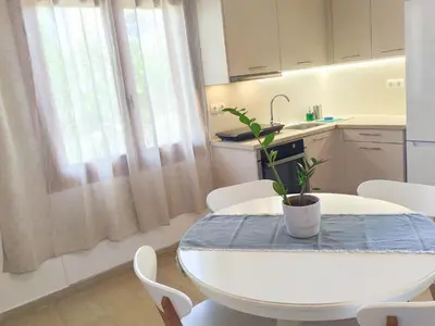 a white table with a potted plant on it in a kitchen at Katerina Sea Apartments in Chania Town