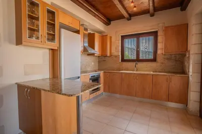 a kitchen with wooden cabinets and a counter top at Villa Petra- Panormic Sea view - Private Pool in Kalyves