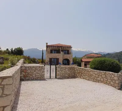 a house with a stone fence and a gate at Villa Petra- Panormic Sea view - Private Pool in Kalyves