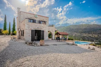 an external view of a stone house with a swimming pool at Villa Petra- Panormic Sea view - Private Pool in Kalyves