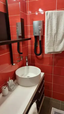 a bathroom with a sink and a red wall at Sandy Point Villas Chania in Agia Marina Nea Kydonias