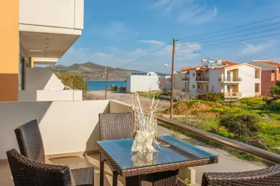a table and chairs on a balcony with a view of the ocean at Sandy Point Villas Chania in Agia Marina Nea Kydonias