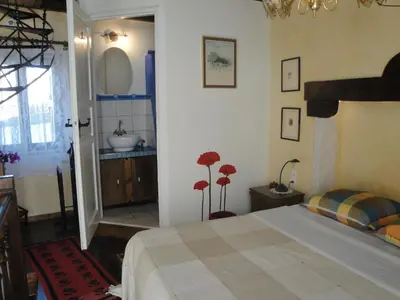 a bedroom with a bed and a bathroom with a sink at Villa Margot in Chania Town