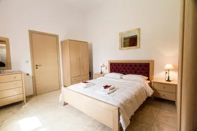 a bedroom with a large bed and two night stands at Agarathos Tradiitonal Apartments & Rooms with Pool Kaliviani -On the road to Balos in Kissamos
