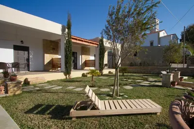 a bench in the yard of a house at Agarathos Tradiitonal Apartments & Rooms with Pool Kaliviani -On the road to Balos in Kissamos