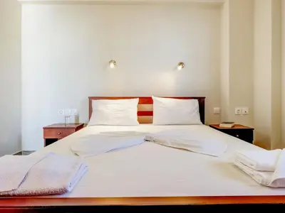 a bedroom with a white bed with two towels on it at Studio in Ravdoucha with Sea View Balcony in Ravdhoúkha