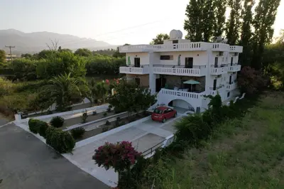 a house with a red car parked in front of it at Zourpos Studios in Kalyves