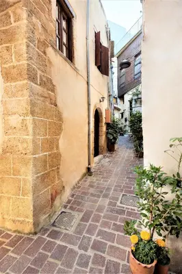 an alley in an old building with potted plants at Old Stone House in Chania Town