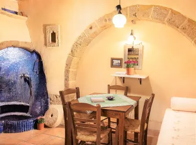 a dining room with a table and chairs and an archway at Old Stone House in Chania Town
