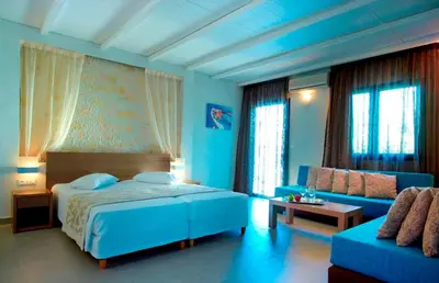 a blue bedroom with a bed and a couch at Minos Village in Agia Marina Nea Kydonias
