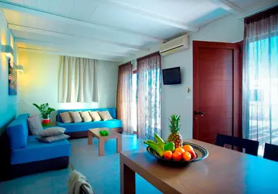a living room with a table with a bowl of fruit on it at Minos Village in Agia Marina Nea Kydonias