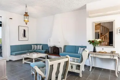 a living room with a blue couch and a table at Traditional Sea Side Cottage in Maleme