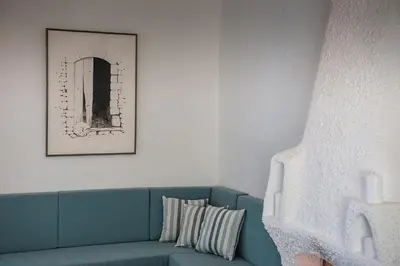 a blue couch in a living room with a picture at Traditional Sea Side Cottage in Maleme