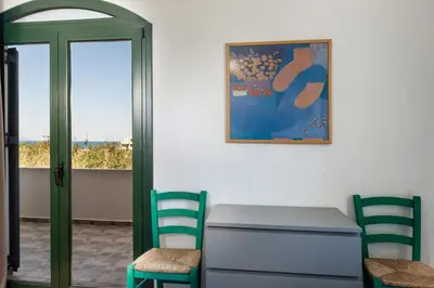 a room with a table and two chairs and a picture at Traditional Sea Side Cottage in Maleme