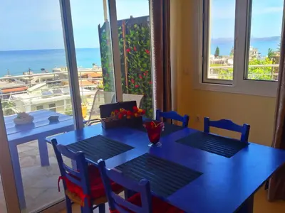 a dining room table with a view of the ocean at Rubini Homes in Agia Marina Nea Kydonias