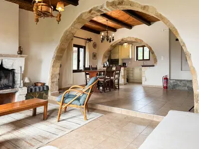 a living room with an archway and a table and chairs at Anna-Malai Penthouse in Megála Khoráfia