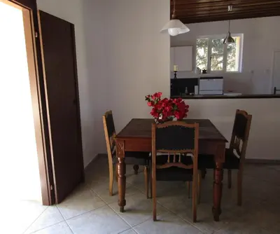 a dining room table and chairs with a vase of flowers on it at Trouli House in Stalos