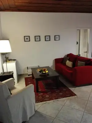 a living room with a red couch and a coffee table at Trouli House in Stalos
