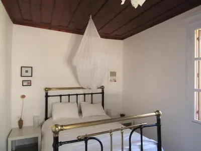 a bedroom with a bed with a wooden ceiling at Trouli House in Stalos