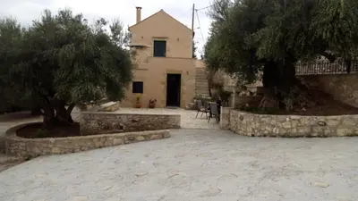 a house with two trees and a stone driveway at Tzitzifes Stone Mansion in Tzitzifés