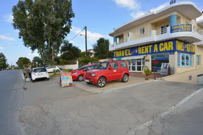 a couple of cars parked in front of a car dealership at Katerina Rooms Agii Apostoloi in Kato Daratso