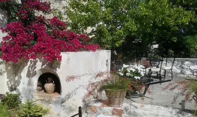 a vase in a niche in a wall with flowers at Petra & Elia in Megála Khoráfia
