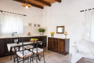 a kitchen with a table and chairs and a couch at Petra & Elia in Megála Khoráfia