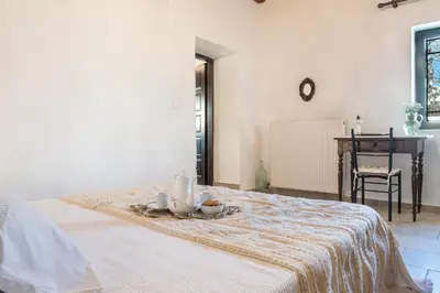 a white room with a bed with candles on it at Petra & Elia in Megála Khoráfia