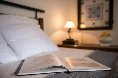 an open book sitting on top of a bed at Petra & Elia in Megála Khoráfia
