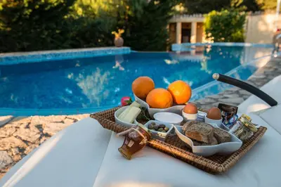 a tray of food on a table next to a pool at Antheia Houses in Vamos