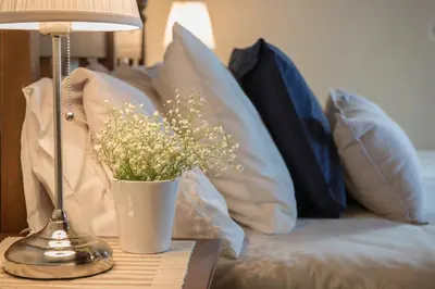 a table with a lamp and a vase with flowers on it at Antheia Houses in Vamos