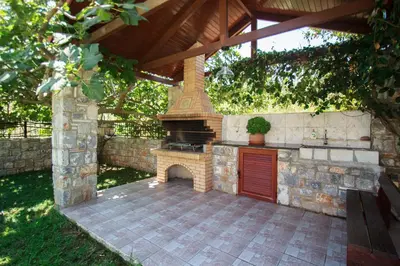 an outdoor kitchen with a grill in a backyard at Erodios Villas 1 in Gerani Chanion