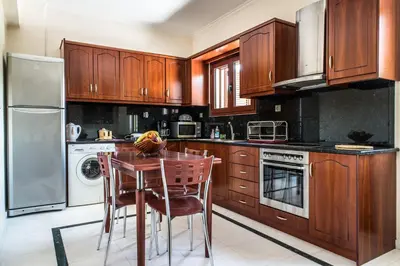 a kitchen with wooden cabinets and a table and chairs at Erodios Villas 1 in Gerani Chanion