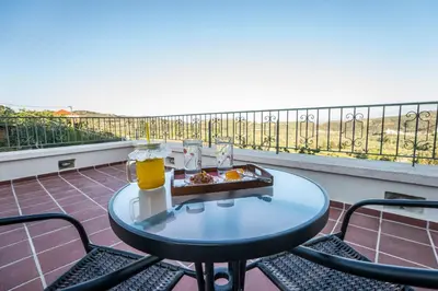 a table with a tray of food on a balcony at Villa Panareti in Kolymvari