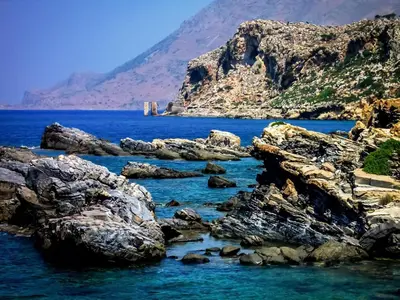 a view of the ocean with rocks in the water at Michalis Holiday Home in Ravdhoúkha