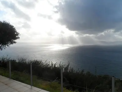 a view of the ocean with the sun shining at Michalis Holiday Home in Ravdhoúkha