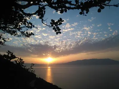 a view of the sun setting over the water at Michalis Holiday Home in Ravdhoúkha