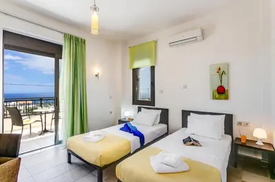 a hotel room with two beds and a balcony at Villa Selena in Stalos