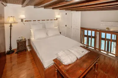 a bedroom with a large bed and a wooden table at Casa Alba Seaview House in Chania Town