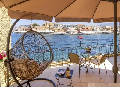 a patio with a table and chairs and a view of the water at Casa Alba Seaview House in Chania Town