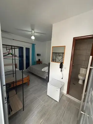 a bedroom with a bunk bed and a bathroom at Scirocco Rooms in Loutro