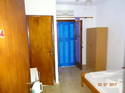 a room with two blue doors and a bed at Scirocco Rooms in Loutro