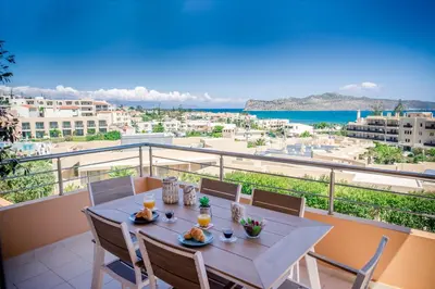 a table on a balcony with a view of the ocean at Lavender Villas Chania in Agia Marina Nea Kydonias