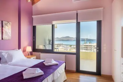 a bedroom with a bed and a large window at Lavender Villas Chania in Agia Marina Nea Kydonias