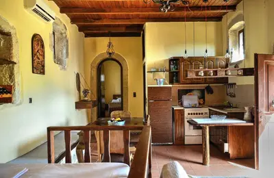 a kitchen with a table and a stove top oven at Elia House in Megála Khoráfia
