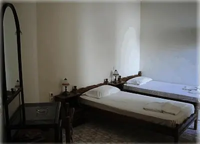 two twin beds in a room with a table and a bed at Constantinos Studios in Chania Town