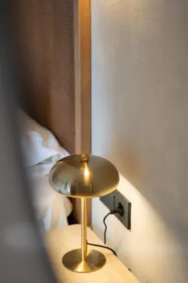a gold lamp on a table next to a bed at Joanna's Place in Palaiochóra