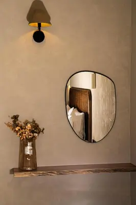 a mirror on a wall with a vase of flowers at Joanna's Place in Palaiochóra