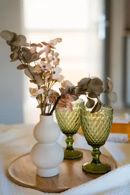 three vases with flowers in them on a table at Joanna's Place in Palaiochóra