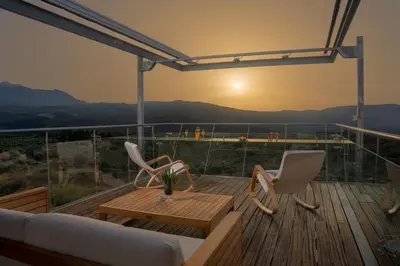 a deck with a couch and chairs and a table at Kaminia Villa in Makhairoí